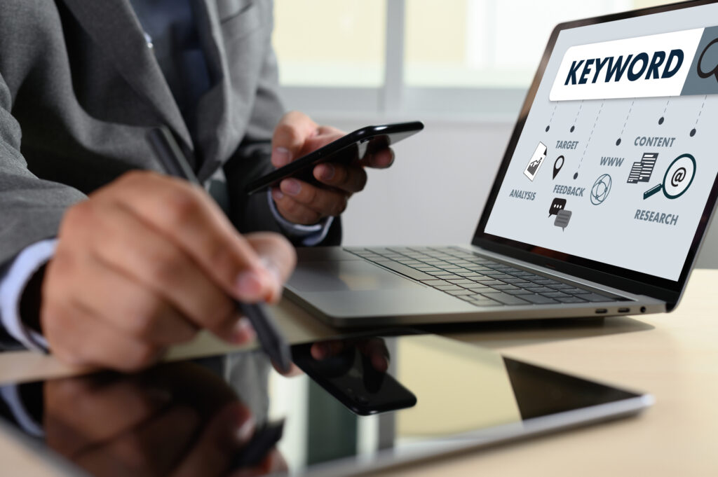 A person with phone, tablet, and laptop doing keyword research for lawyer SEO